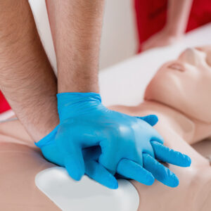 a person performing cpr on a training aid